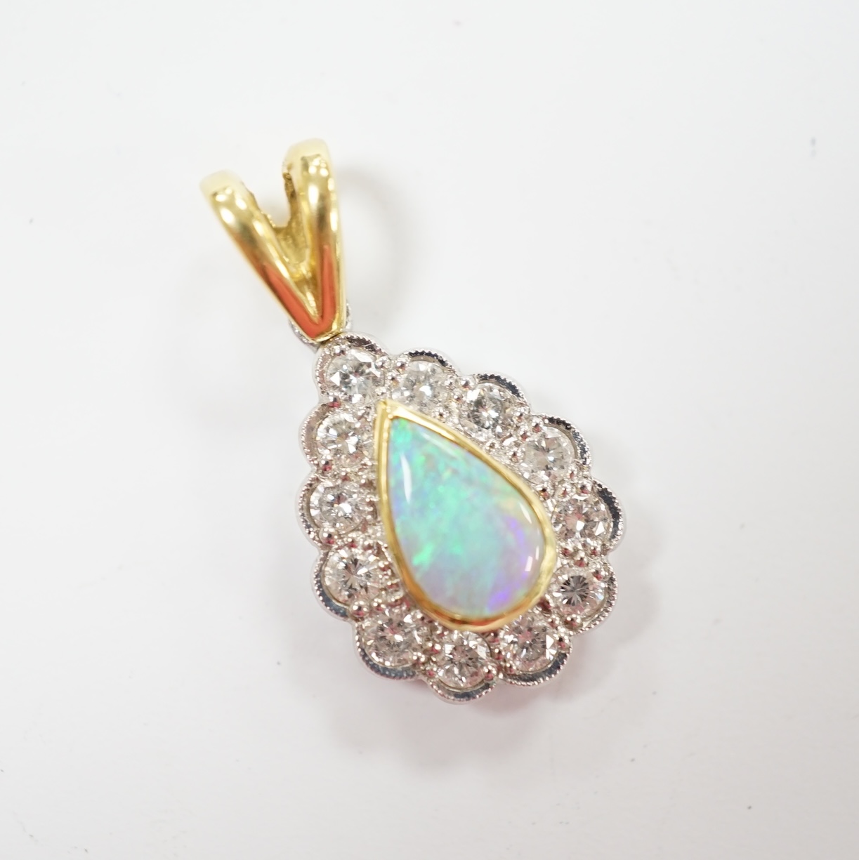 A modern 18ct gold, white opal and diamond set pear shaped cluster pendant, overall 23mm, gross weight 2.6 grams.